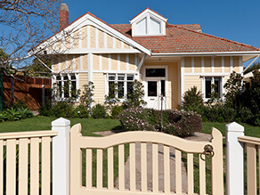 Cream Exterior Bungalow Weatherboard with White Trims and Fretwork with Luscious Green Garden 